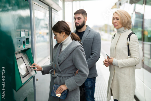 Passengers buying ticket at ticket vending machine