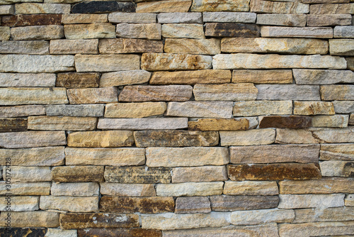 A wall of beautiful stone on the street. Background. Texture.