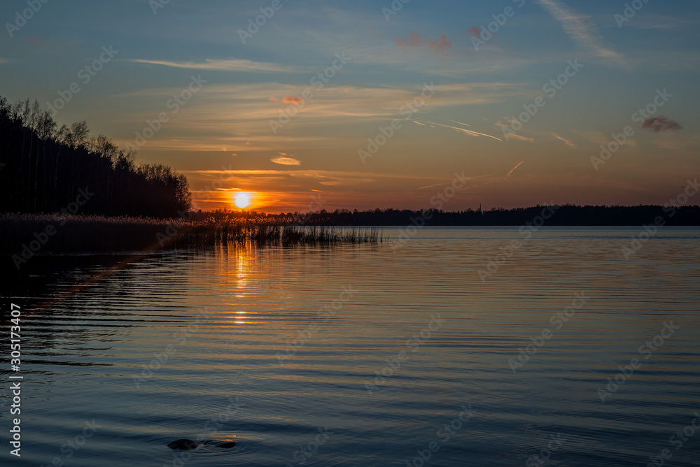 sunset on the lake with colorful sky and sunbeam