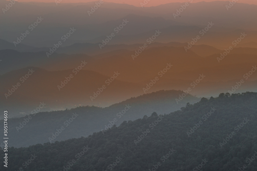 The blurred background of the twilight light in the evening under the trees, surrounded by mountains and cool breeze, seen during the tourist spots.