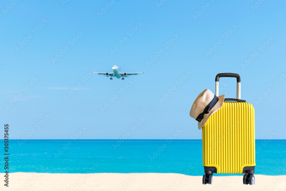 Summer travel and plan with yellow suitcase luggage in the sand beach. Travel in the holiday trips, airplane and blue sky background. Summer and Travel Concept Summer travel and plan with yellow suitcase luggage in the sand beach. Travel in the holiday trips, airplane and blue sky background. Summer and Travel Concept