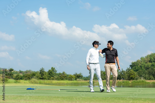 Group Professional Golfer asian man walking and hug for friendship after finish put ball on green. Hobby in holiday and vacation with friends. Lifestyle and Sport Concept