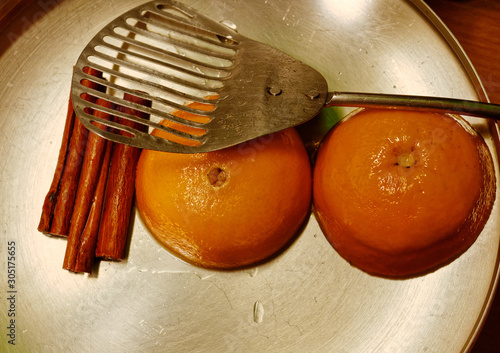 cinnamon sticks and orange cut in two for the traditional honey syrup photo