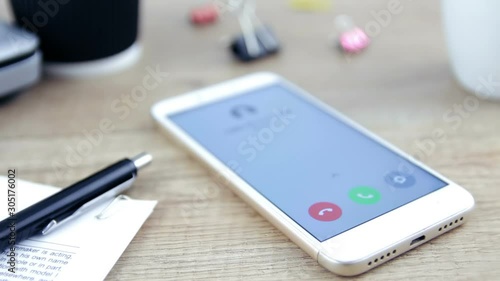 A telephone on a desk rings with a phone call