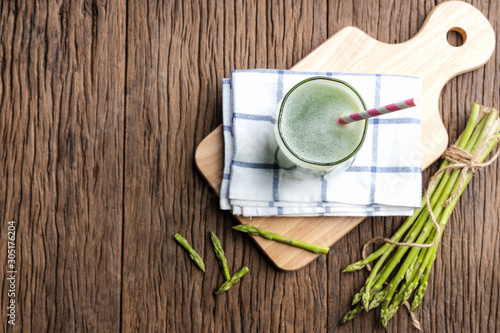 Fototapeta Naklejka Na Ścianę i Meble -  Top view of healthy green smoothie asparagus on cutting board and wooden background. food and drink for health concept.