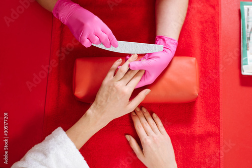 Young woman takes manicure treatment at the beauty salon