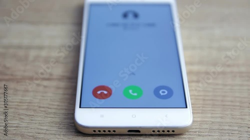 phone with incoming call on the screen over a table