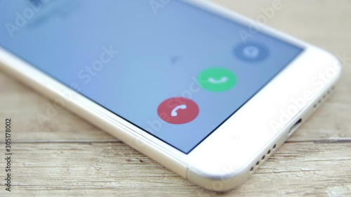 phone with incoming call on the screen over a table