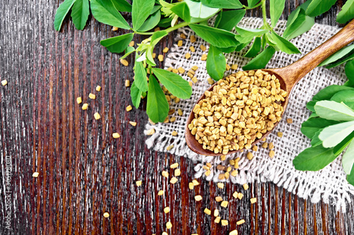 Fenugreek in spoon with leaves on board top