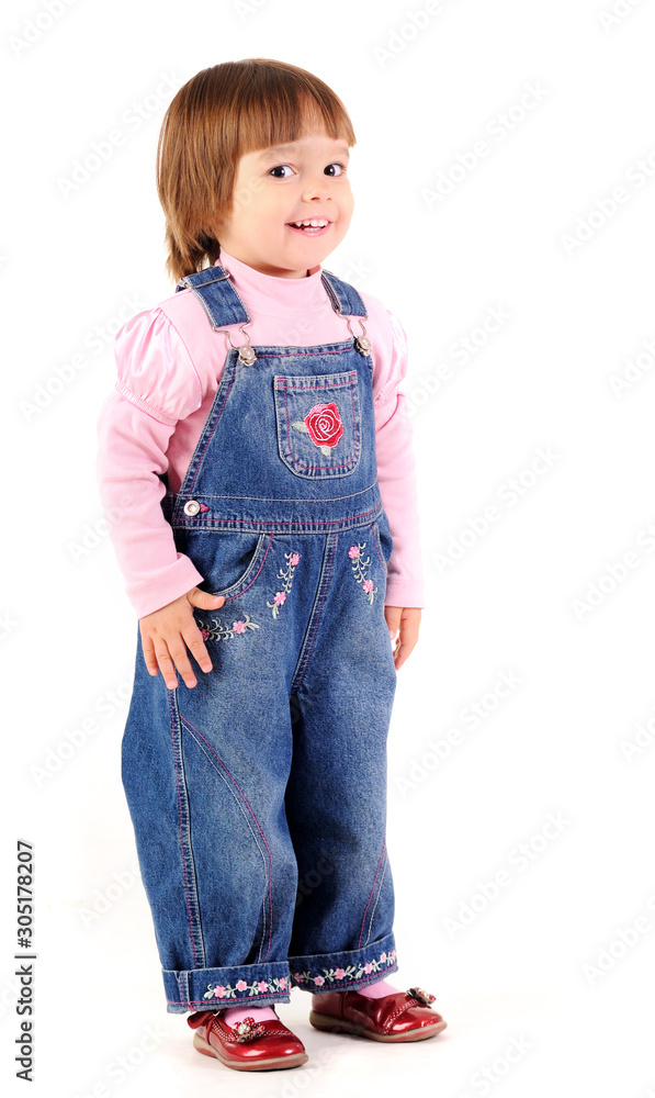 Small girl in jeans jumpsuit walking and smiling Small girl in jeans jumpsuit walking and smiling