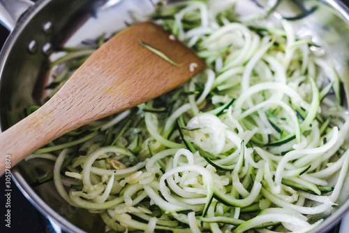 meal-prepping healthy wholesome meals concept, zucchini noodles cooking in pot on stovetop