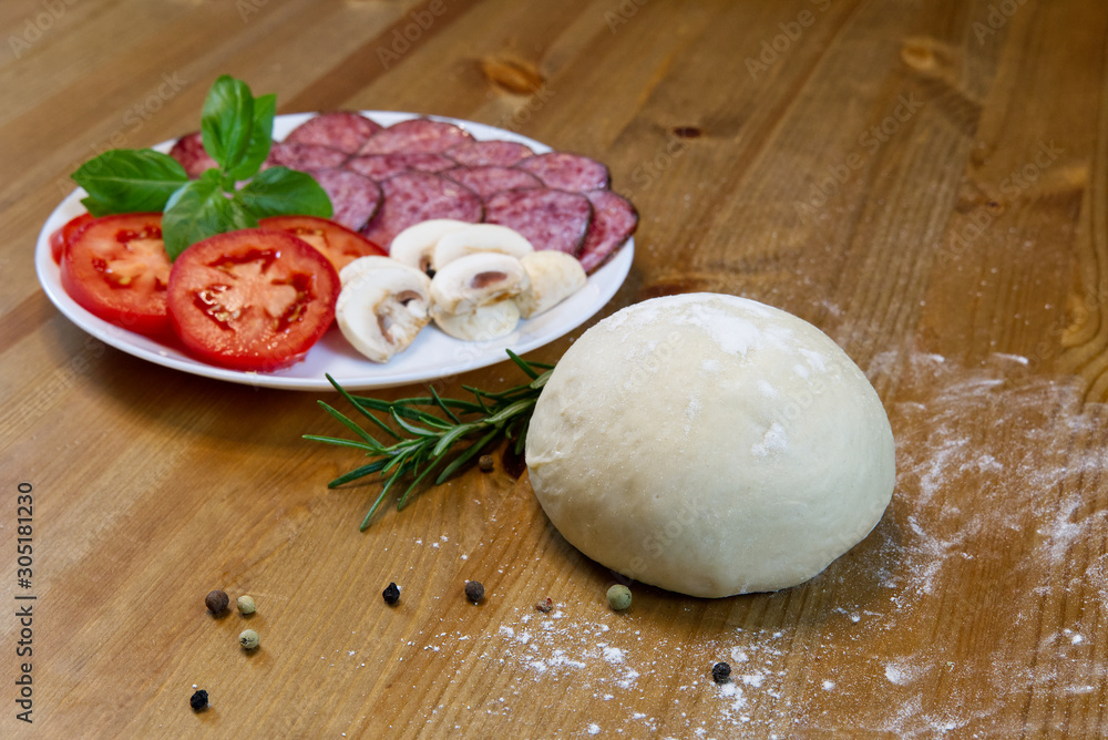 ingredients for cooking italian pepperoni pizza at home. dough, mozarella, salami, tomato, basil, olive oil, rosemary, pepper, garlic ingredients for cooking italian pepperoni pizza at home. dough, mozarella, salami, tomato, basil, olive oil, rosemary, pepper, garlic