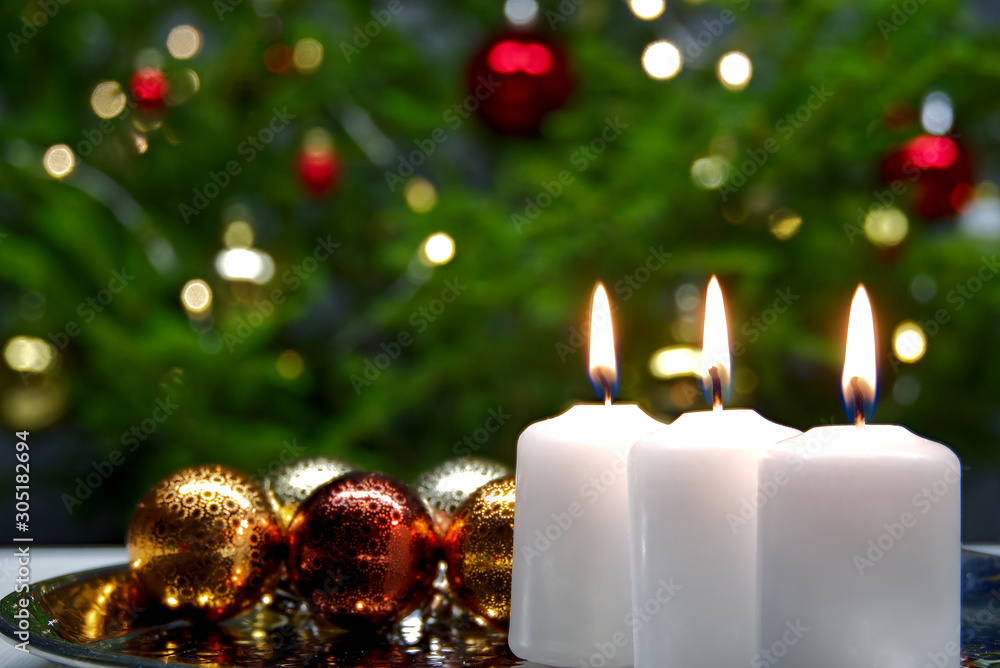 Fototapeta three burning candles with Christmas decoration. xmas composition.
