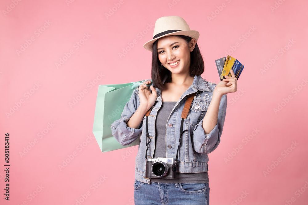 Tourist woman in summer casual clothes.Asian Smiling woman .Passenger traveling abroad to travel on pink background.She going to summer vacation.Travel trip funny Credit card on holiday. Tourist woman in summer casual clothes.Asian Smiling woman .Passenger traveling abroad to travel on pink background.She going to summer vacation.Travel trip funny Credit card on holiday.