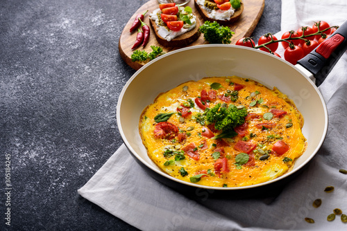 Fotografie healthy Breakfast of omelet with cherry tomatoes and spinach in frying pan and t