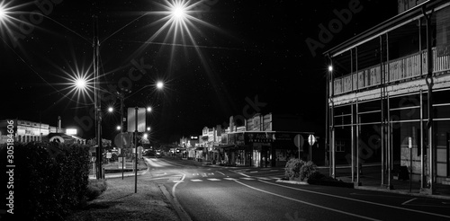 A magic night  with bright night lights and starry sky after midnight on empty Main Street in the town of Atherton. The Atherton Tableland, Far North Queensland, Australia.Black and White Photography.