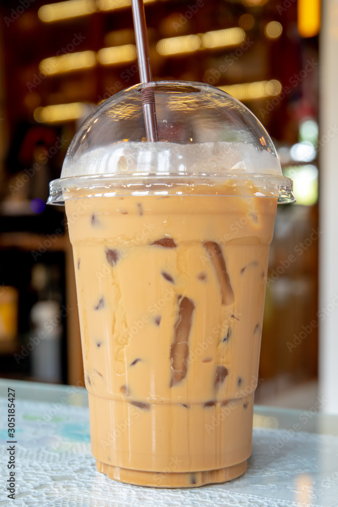 Coffee in plastic glass on the table at coffee shop.