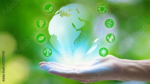 Hand holding with earth and environment icons over the Network connection on nature background, Technology ecology concept.