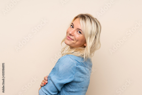 Young blonde woman over isolated background laughing