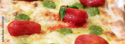 Pizza with pesto sauce and red peeled Tomatoes photo