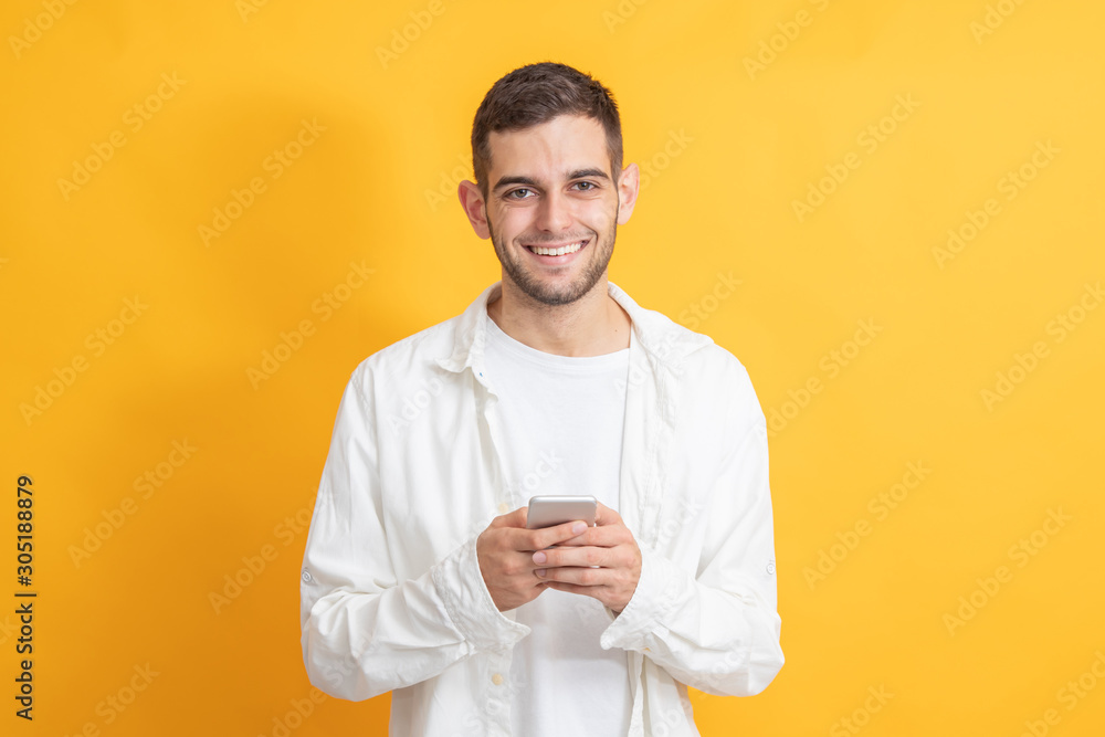 portrait of young man with mobile phone on color background portrait of young man with mobile phone on color background