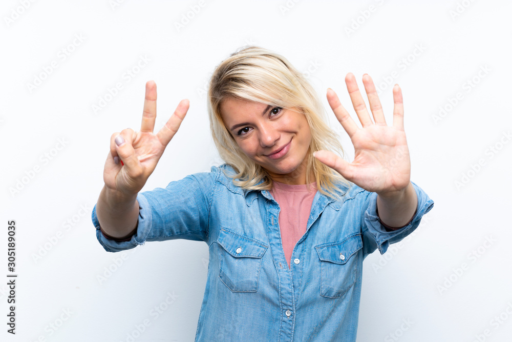 Young blonde woman over isolated white background counting seven with fingers Young blonde woman over isolated white background counting seven with fingers