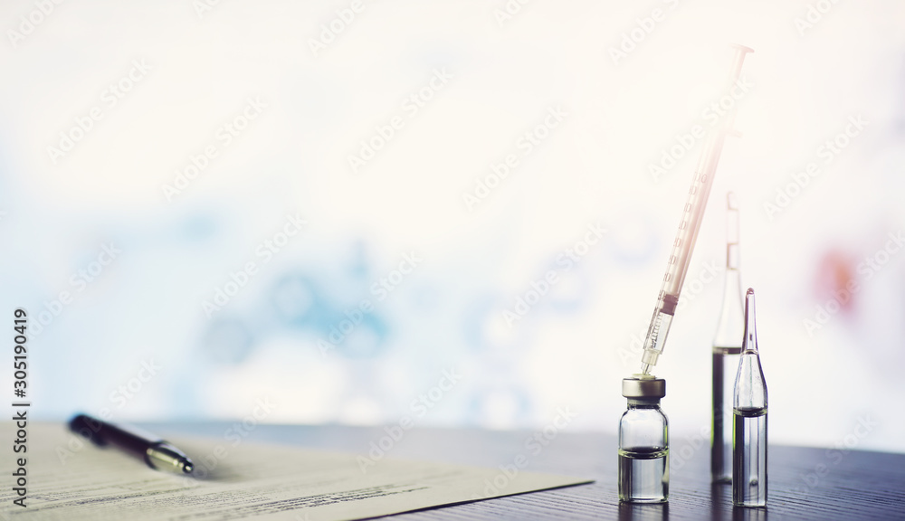 A man signs a medical document. Medical equipment on the table. Stethoscope and ampoules with syringes. Makes notes in the office. Medical center. A man signs a medical document. Medical equipment on the table. Stethoscope and ampoules with syringes. Makes notes in the office. Medical center.
