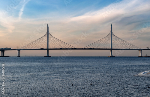 Cityscape - View of cable-stayed bridge and bay on a frosty day at sunset, golden lighting