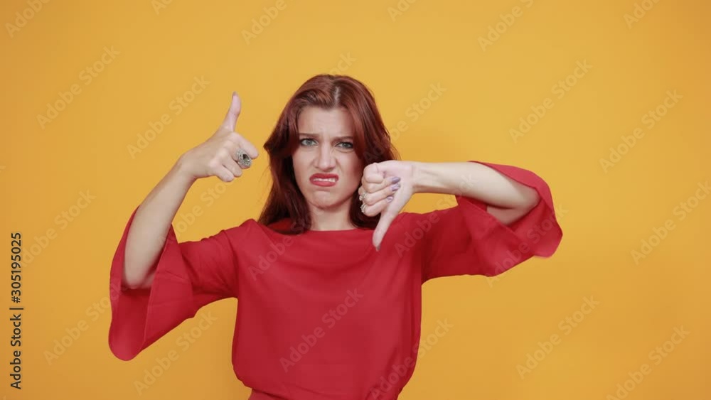 The lady in red dress is confused between to respond with like or dislike. She has no idea what to say, so she is smiling as she can't decide. The lady in red dress is confused between to respond with like or dislike. She has no idea what to say, so she is smiling as she can't decide.