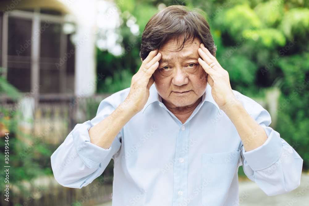 Portrait of an elderly man with headache.senior man covering his face with his hands.vintage tone..