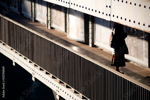 A woman walking on the bridge. Silhouette of a woman