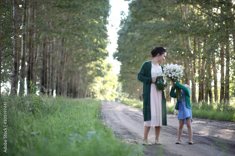 Fototapeta premium Mother with daughter walking on a road