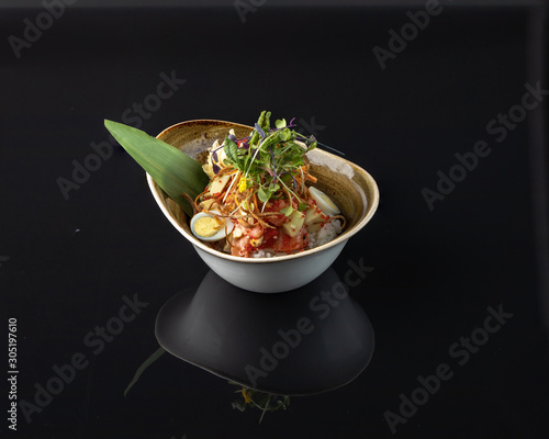 Salmon poke Salmon, avocado, rice, sesame, cashew, sesame sauce, ginger, carrot, green onion, quail egg, tobiko caviar, orange