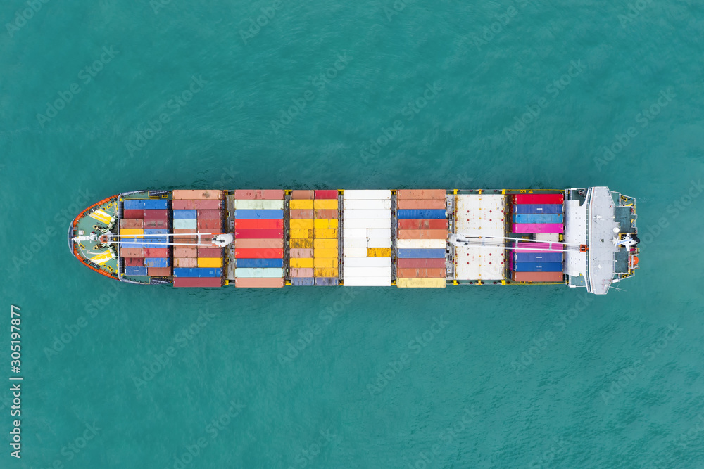 View from above, stunning aerial view of a cargo ship sailing with hundreds of colored containers direct to the port of Singapore. The Port of Singapore is the second biggest port in the world.