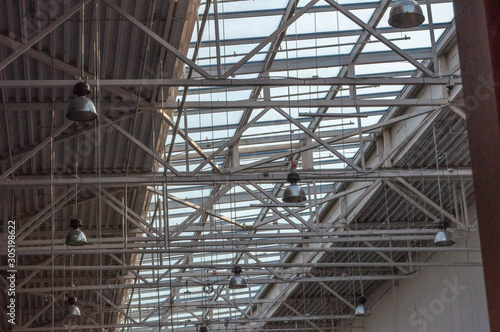 a ceiling in a production hall with a large svent window and luminaires suspended on long rods