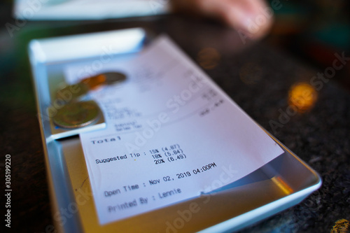 a couple of dollars tip along with a check for lunch in a cafe on the table