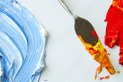 Spots of blue and red oil paints on a white canvas