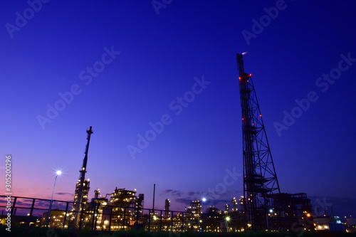 Industry night landscape at twilight time in Map Ta Phut Industrial Estate,Rayong,Thailand. Silhouette the buildings and lights shine bright at night. 