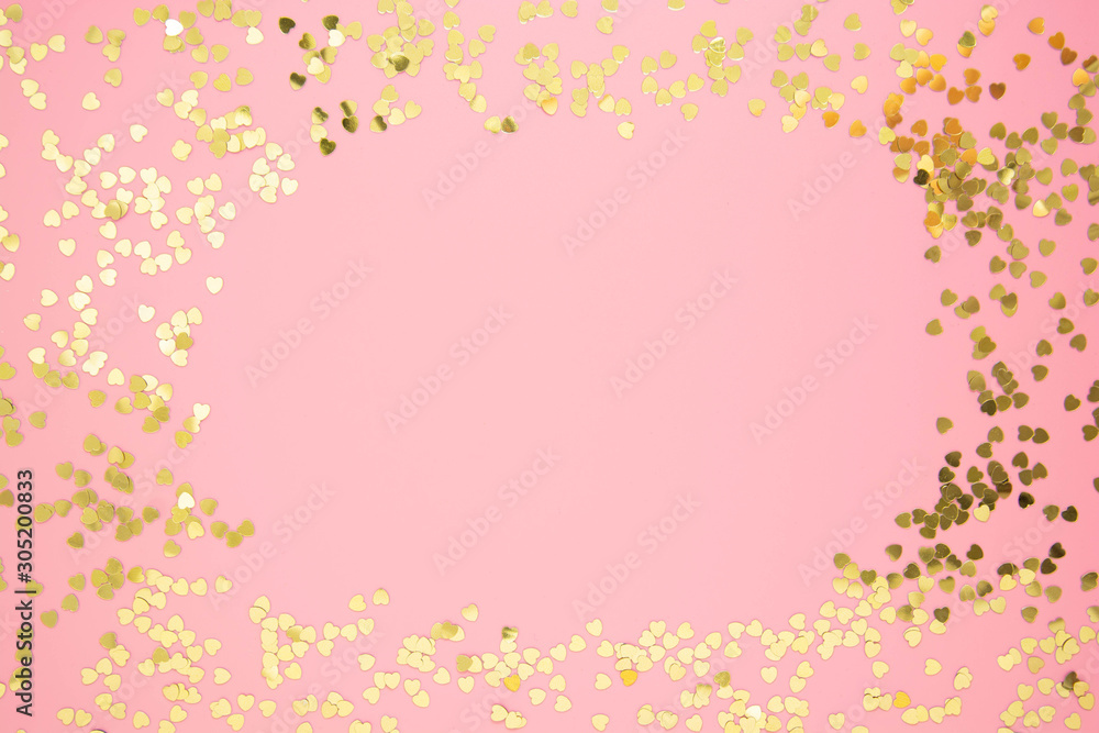 Abstract textured backgraund, golden heart shape glitter over pink background. Valentine's Day, love, birthday, party concept. Flat lay with copy space.