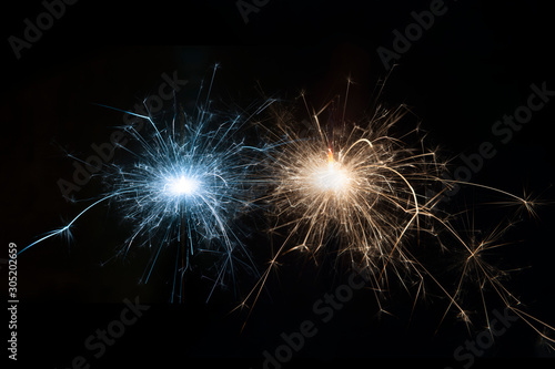 Burning sparkler on black background