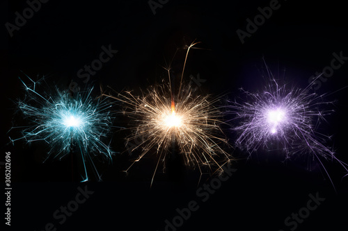 Burning sparkler on black background