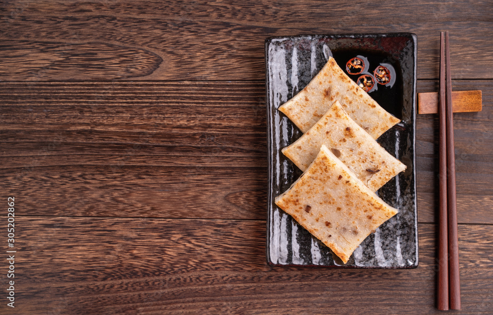 Delicious turnip cake, Chinese traditional radish cake in restaurant with soy sauce for new year's dishes, close up, copy space, top view, flat lay. Delicious turnip cake, Chinese traditional radish cake in restaurant with soy sauce for new year's dishes, close up, copy space, top view, flat lay.