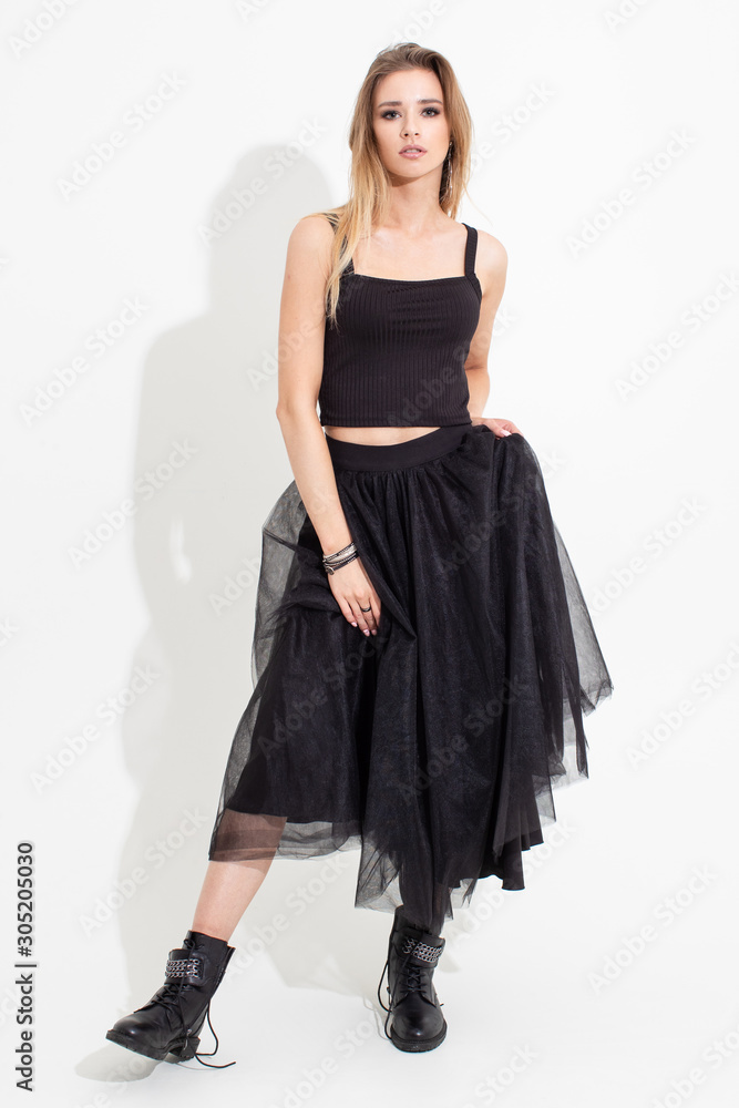 Girl in t-shirt and black skirt posing on a white background. Fashion shooting Girl in t-shirt and black skirt posing on a white background. Fashion shooting