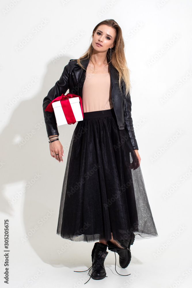Girl holding a gift in a white box with a red ribbon and posing on a white background Girl holding a gift in a white box with a red ribbon and posing on a white background