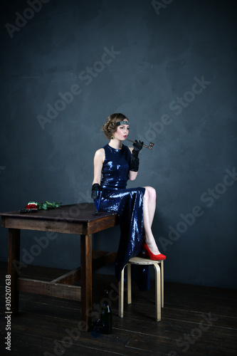 girl in a blue evening dress with a pipe