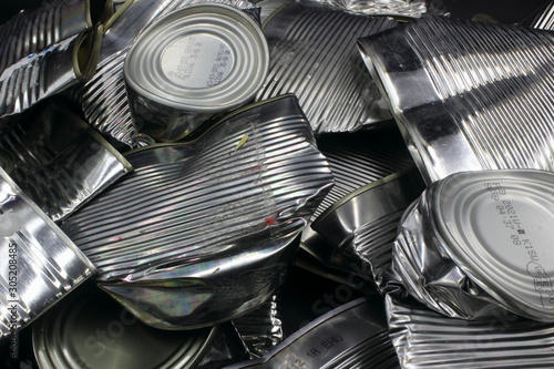 pile of crushed food aluminium tin cans ready for recycling isolated on a black background	