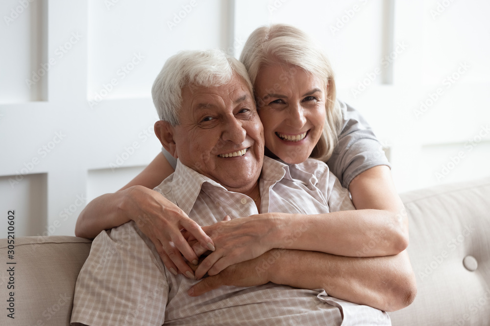 Pleasant middle aged woman embracing happy 80s father. Pleasant middle aged woman embracing happy 80s father.