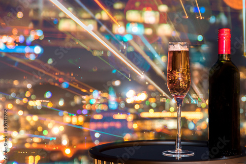 A glass of rose wine over light city blurred background and fireworks, Christmas festive celebration. End of the year, Welcome to New Year 2019. Good long holiday vacation with new thing when start up