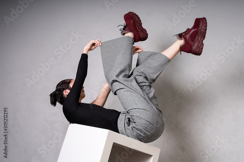 womens check pants, Red warm winter high soled sneakers, and a blouse. Caucasian model with short haircut posing in fashionable clothes in a photo studio