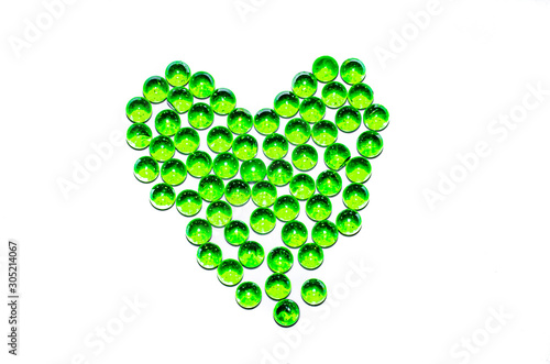 Green glass balls. Glass ball on a white background. Macro from different angles and in the form of a heart.